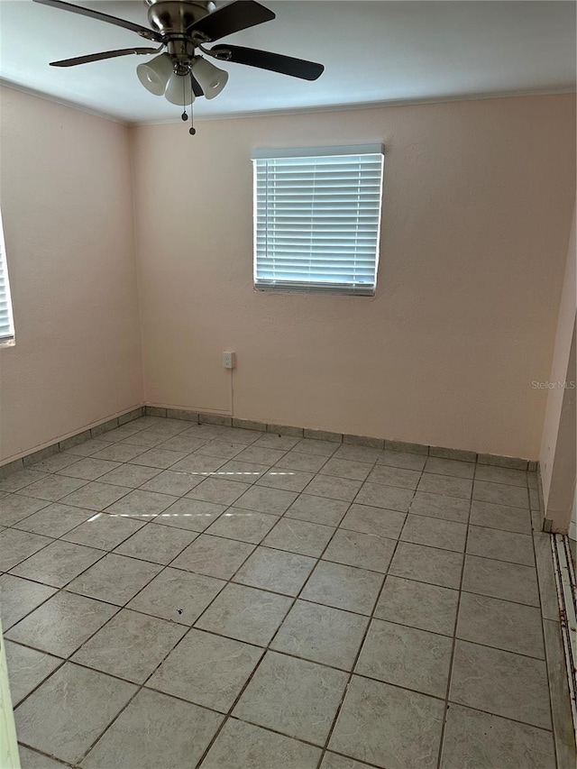 unfurnished room with ceiling fan and light tile patterned flooring