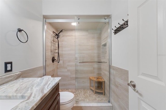 bathroom with toilet, vanity, and an enclosed shower