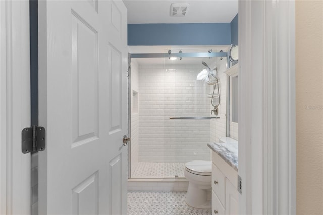 bathroom featuring vanity, toilet, tile patterned floors, and a shower with door