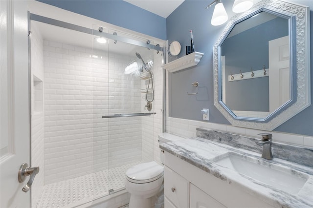 bathroom with a shower with door, toilet, and vanity