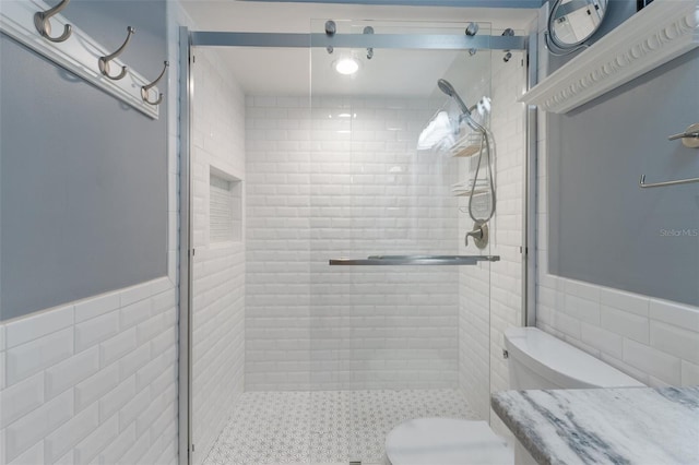 bathroom with a shower with shower door, tile walls, and toilet