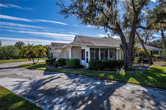 single story home with a sunroom and a front yard