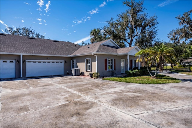 ranch-style home featuring central AC, a garage, and a front yard