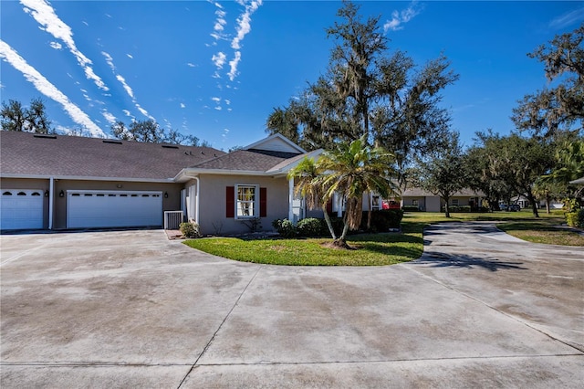 ranch-style home with a garage, central AC unit, and a front yard