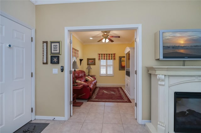 entryway featuring light tile patterned floors, crown molding, and ceiling fan