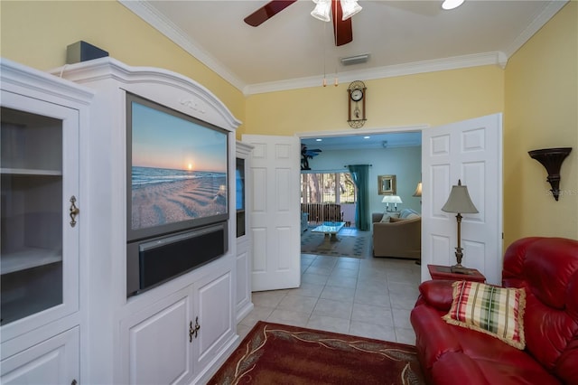 living room featuring light tile patterned floors, crown molding, and ceiling fan