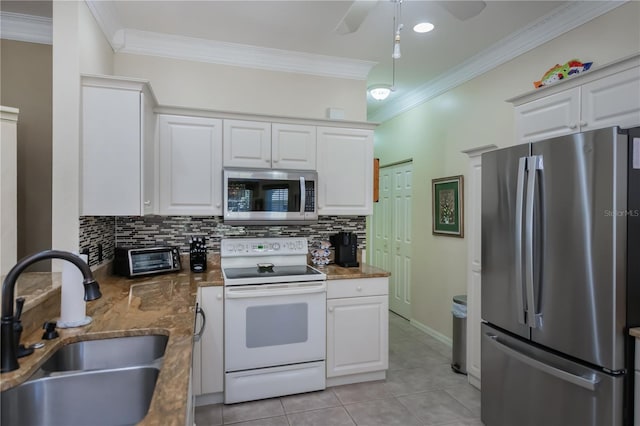 kitchen with sink, light tile patterned floors, appliances with stainless steel finishes, decorative backsplash, and white cabinets