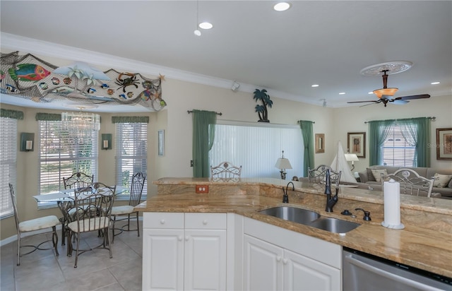 kitchen featuring sink, crown molding, light stone counters, stainless steel dishwasher, and white cabinets