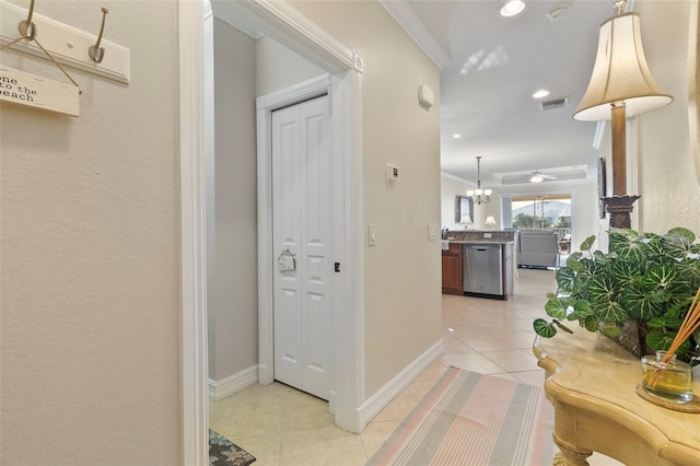 hall featuring ornamental molding, a chandelier, and light tile patterned flooring