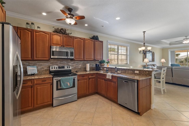 kitchen with decorative light fixtures, sink, appliances with stainless steel finishes, and dark stone countertops