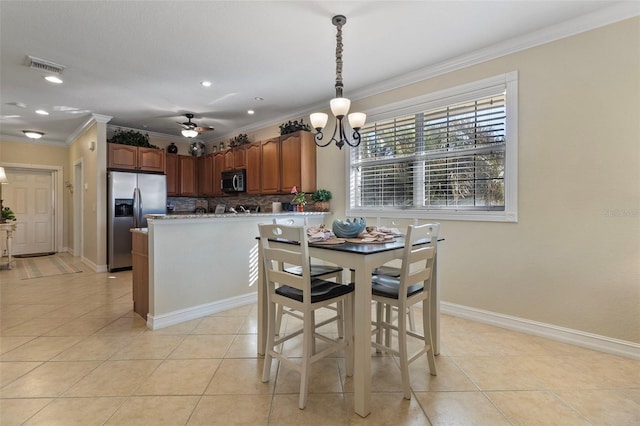 tiled dining room featuring ceiling fan with notable chandelier and crown molding