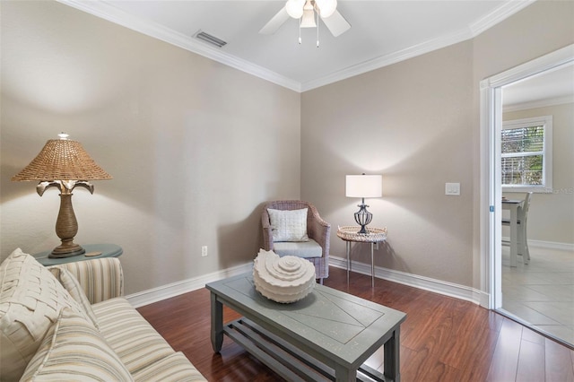 sitting room featuring ceiling fan, dark wood-type flooring, and ornamental molding