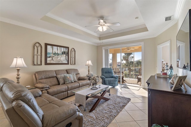 tiled living room featuring ceiling fan, a tray ceiling, and crown molding