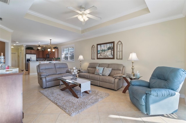 tiled living room with a raised ceiling and crown molding