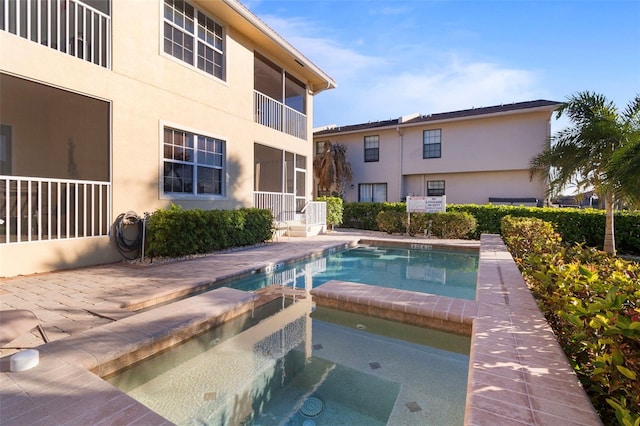 view of swimming pool featuring an in ground hot tub