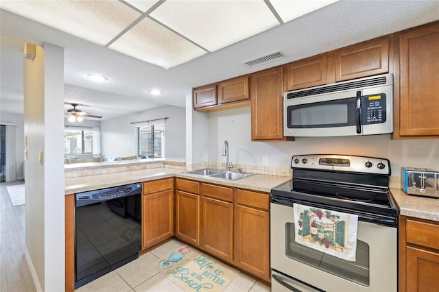 kitchen with sink, light tile patterned floors, ceiling fan, and appliances with stainless steel finishes