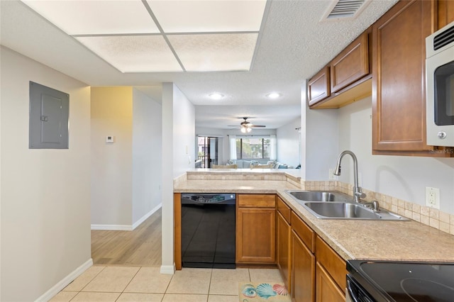 kitchen featuring sink, range with electric stovetop, light tile patterned floors, electric panel, and black dishwasher