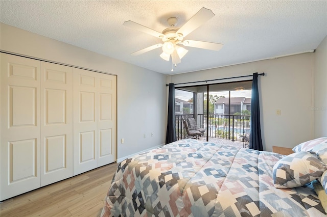 bedroom featuring a closet, access to outside, ceiling fan, a textured ceiling, and light hardwood / wood-style flooring