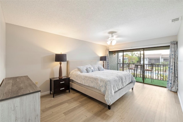 bedroom with ceiling fan, access to exterior, light hardwood / wood-style floors, and a textured ceiling