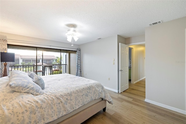 bedroom with ceiling fan, light wood-type flooring, a textured ceiling, and access to outside