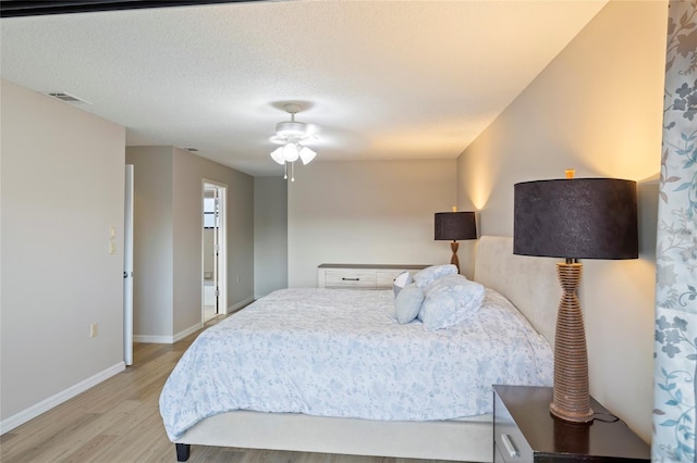 bedroom featuring a textured ceiling, ceiling fan, and light hardwood / wood-style flooring