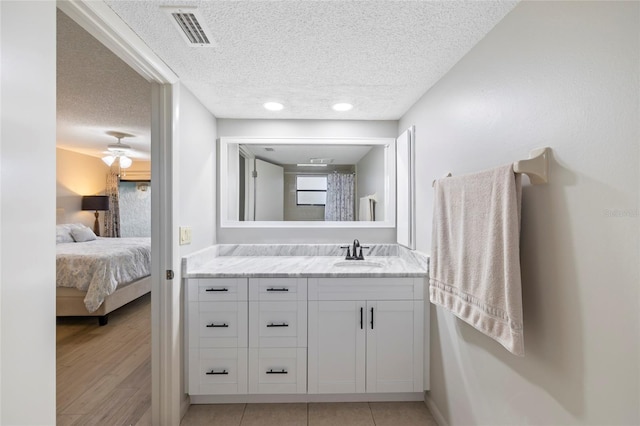 bathroom featuring vanity, tile patterned flooring, a textured ceiling, and ceiling fan