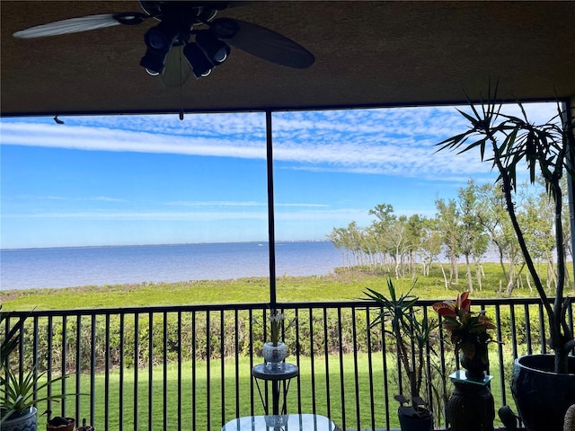 exterior space with ceiling fan and a water view