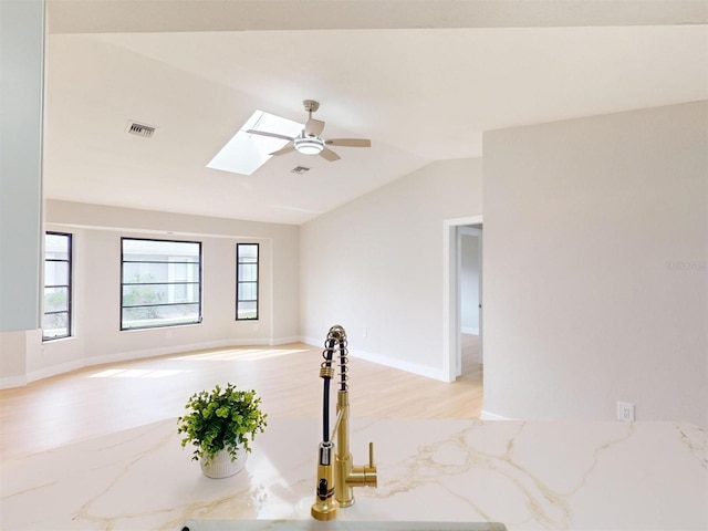 spare room featuring ceiling fan and lofted ceiling with skylight