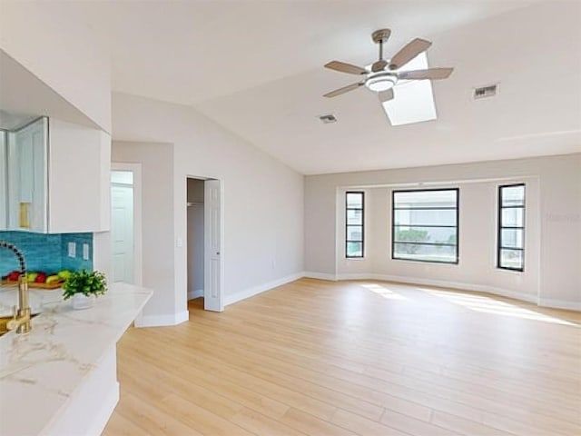 living room featuring ceiling fan, a healthy amount of sunlight, light hardwood / wood-style flooring, and lofted ceiling