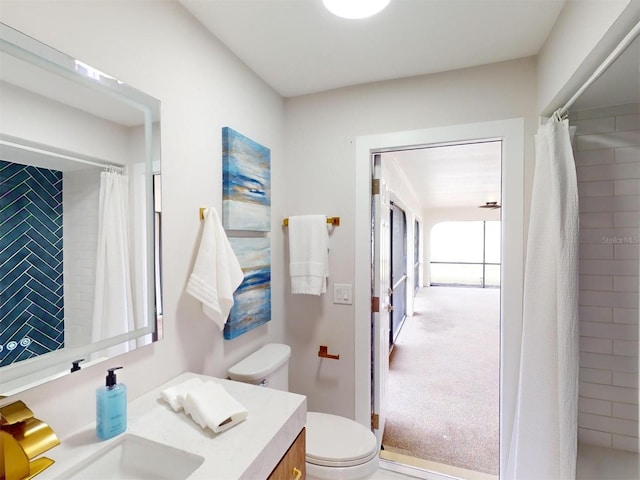 bathroom featuring toilet, a shower with shower curtain, and vanity