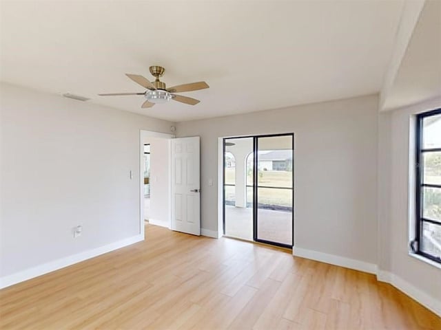 spare room featuring ceiling fan, light hardwood / wood-style floors, and a wealth of natural light