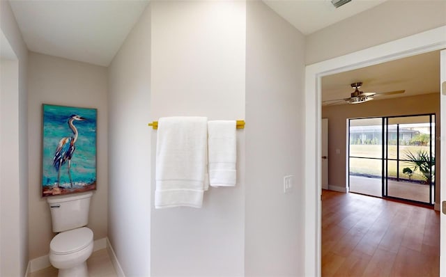 bathroom with hardwood / wood-style floors, toilet, and ceiling fan