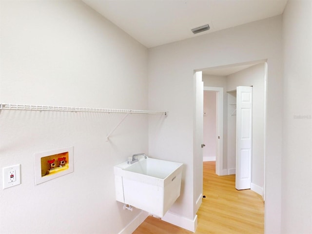 laundry room with sink, hardwood / wood-style flooring, and washer hookup