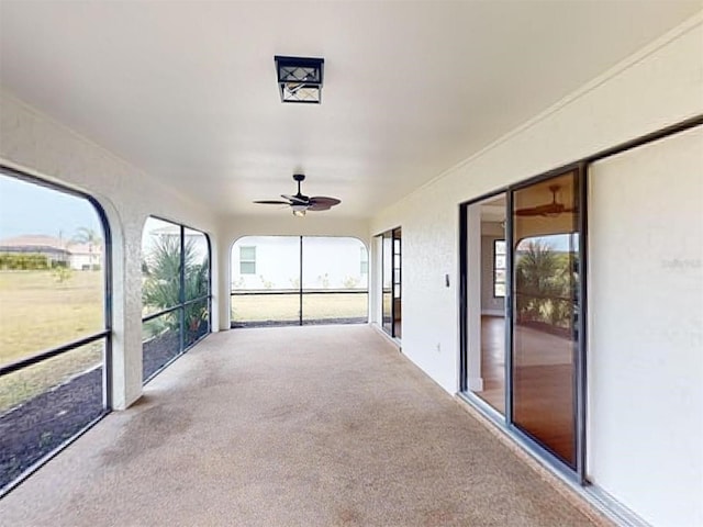 unfurnished sunroom with plenty of natural light and ceiling fan