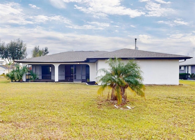 rear view of property with a sunroom and a lawn