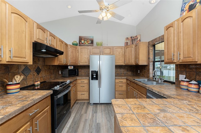 kitchen with tasteful backsplash, appliances with stainless steel finishes, sink, and tile counters