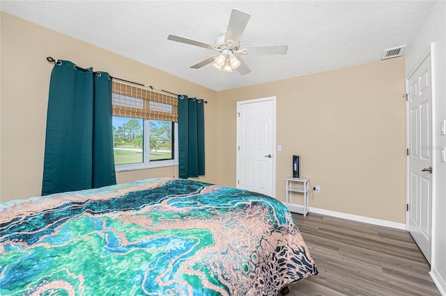 bedroom featuring hardwood / wood-style floors, a textured ceiling, and ceiling fan