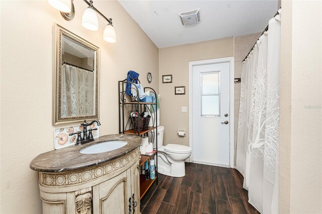 bathroom with vanity, wood-type flooring, and toilet