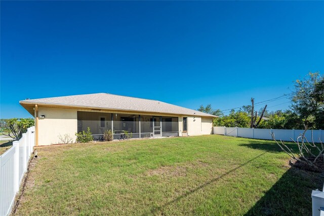 back of house with a yard and a sunroom