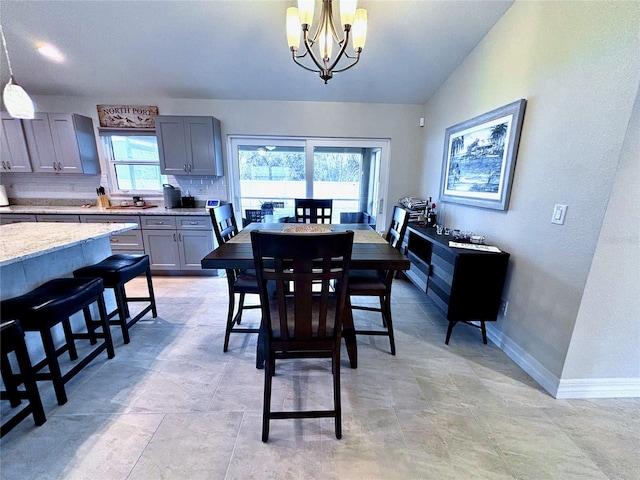 dining space with a chandelier, vaulted ceiling, and a wealth of natural light