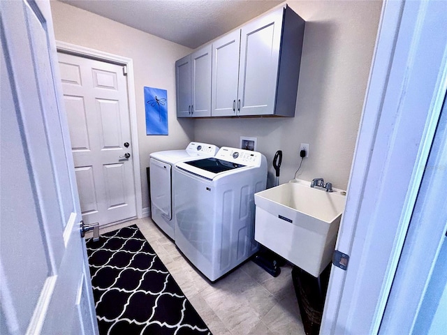 clothes washing area featuring cabinets, separate washer and dryer, and sink