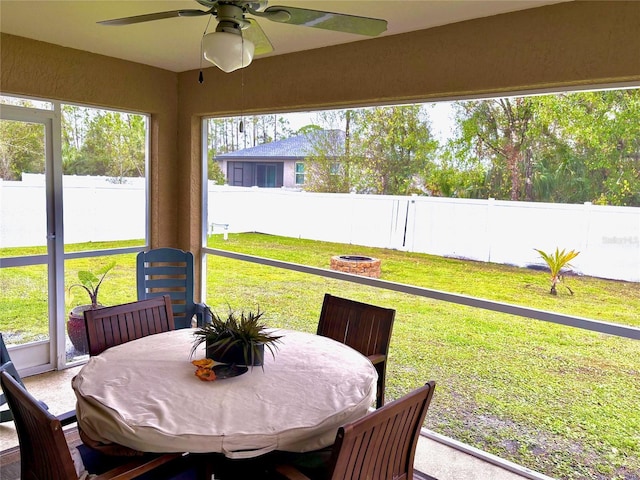 sunroom / solarium with a healthy amount of sunlight and ceiling fan