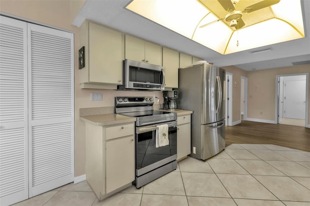 kitchen with ceiling fan, light tile patterned floors, and appliances with stainless steel finishes