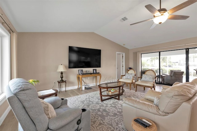 living room featuring light hardwood / wood-style floors, vaulted ceiling, and ceiling fan