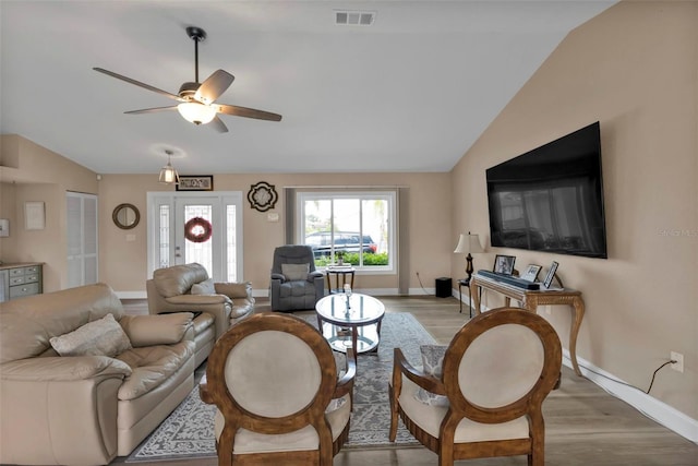 living room featuring ceiling fan, light hardwood / wood-style flooring, and lofted ceiling