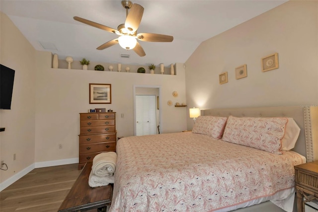 bedroom featuring ceiling fan, hardwood / wood-style floors, and lofted ceiling