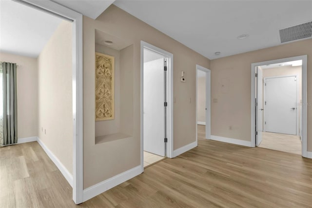 corridor with light hardwood / wood-style floors