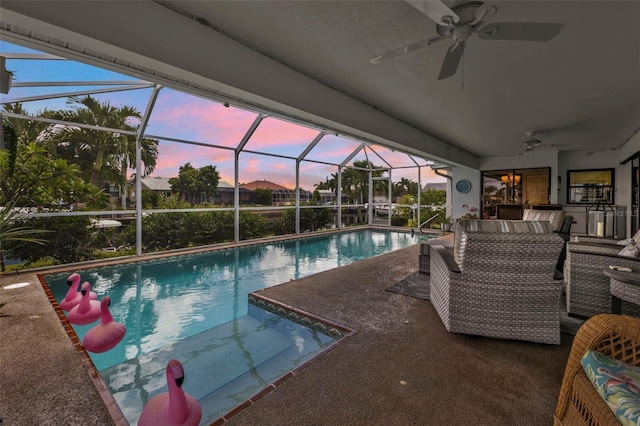 pool at dusk featuring ceiling fan, a patio area, a lanai, and outdoor lounge area