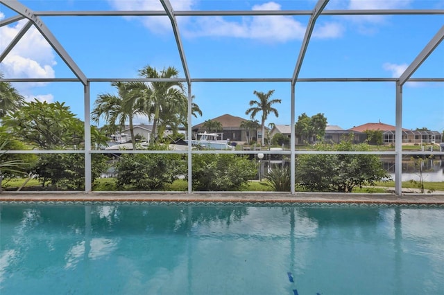 view of swimming pool with a lanai and a water view