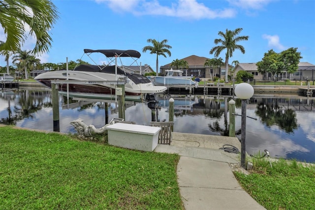 dock area with a lawn and a water view